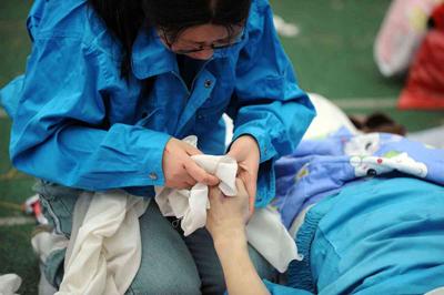 5月14日，張關蓉在擦拭丈夫譚千秋的遺體。